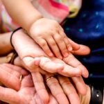 person wearing black watch holding babys hand