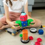 girl in white shirt playing with blue and red car toy