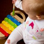 baby playing multicolored xylophone toy