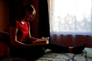 woman in red tank top reading book