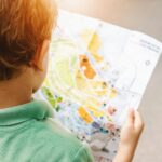 boy standing while reading map