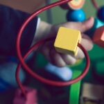 selective focus photo of baby playing activity cube