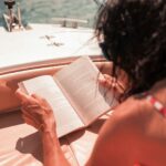 woman riding boat reading book