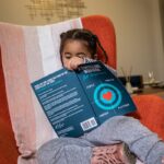 boy in gray sweater holding blue box