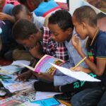 boy in blue and white plaid shirt reading book