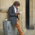 man sitting beside cup of coffee